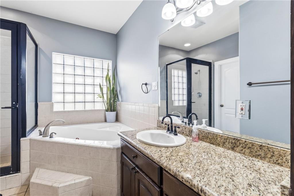22602 Rio Rancho Road Harlingen, TX 78552 - Photo 14 of 26 a bathroom with a granite countertop sink and a large mirror