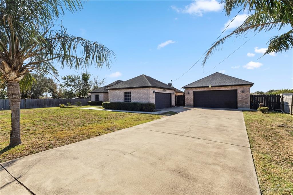 22602 Rio Rancho Road Harlingen, TX 78552 - Photo 3 of 26 a front view of a house with a yard and garage