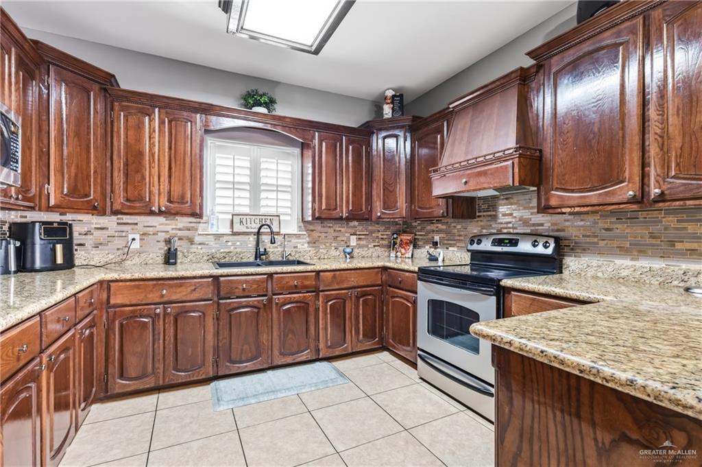 22602 Rio Rancho Road Harlingen, TX 78552 - Photo 8 of 26 a kitchen with stainless steel appliances granite countertop wooden cabinets a stove top oven a sink and dishwasher