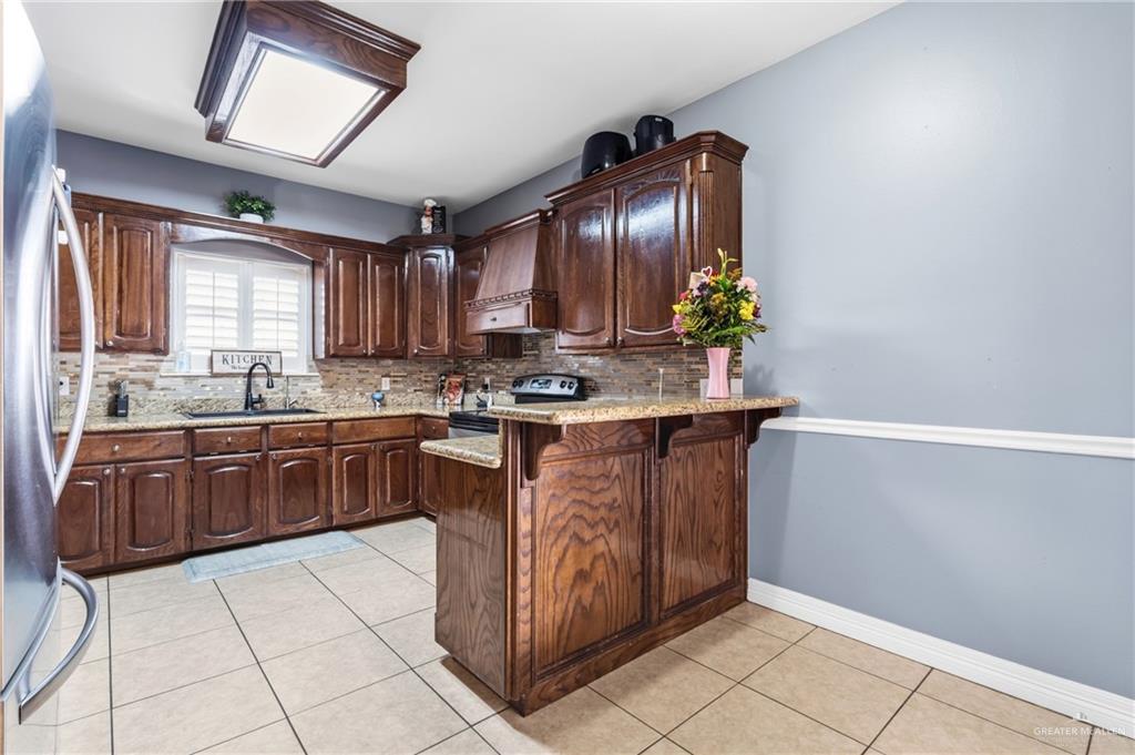 22602 Rio Rancho Road Harlingen, TX 78552 - Photo 9 of 26 a kitchen with stainless steel appliances granite countertop a stove a sink and a microwave