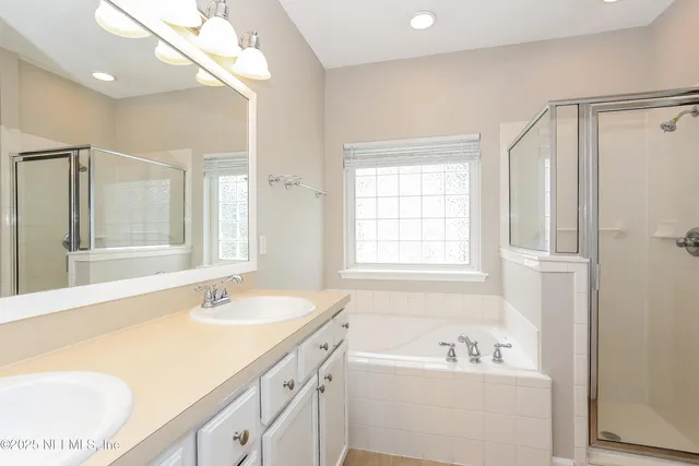 a bathroom with a tub sink and mirror