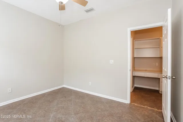 a view of an empty room and a ceiling fan