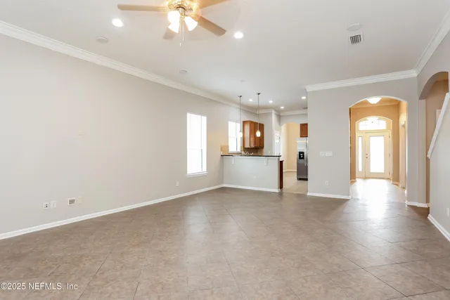 an empty room with a kitchen and fireplace