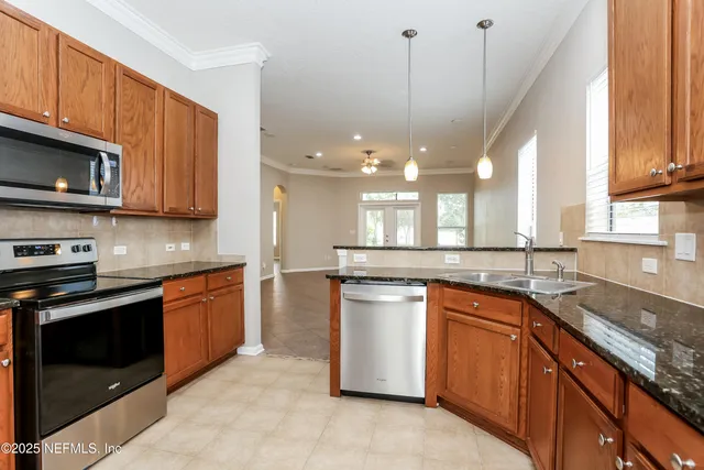 a kitchen with stainless steel appliances granite countertop a sink a stove and a microwave