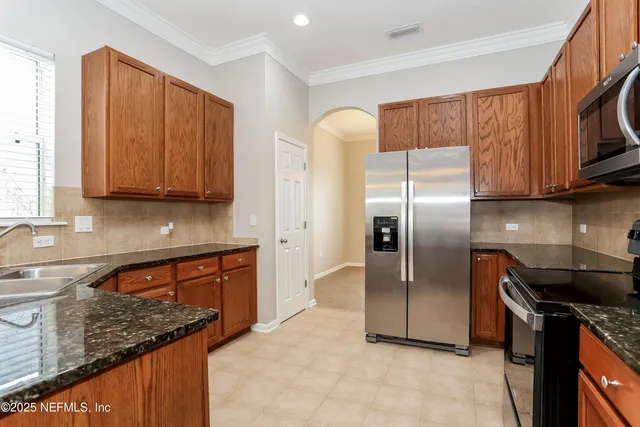 a kitchen with stainless steel appliances granite countertop a refrigerator a stove top oven a sink and dishwasher