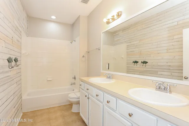 a bathroom with a granite countertop sink a toilet and bathtub