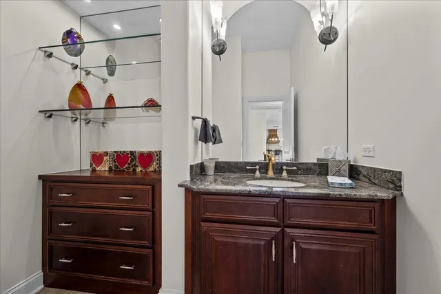 a bathroom with a granite countertop sink vanity and a mirror