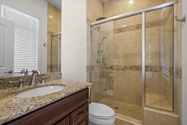 a bathroom with a granite countertop sink toilet and shower