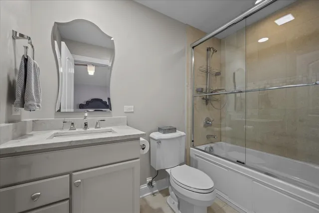 a bedroom with a bed a chair and potted plant on the dresser