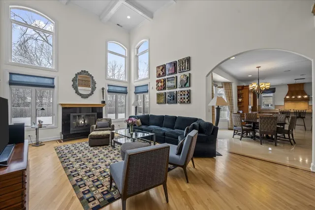 a living room with furniture a fireplace a rug and a large window