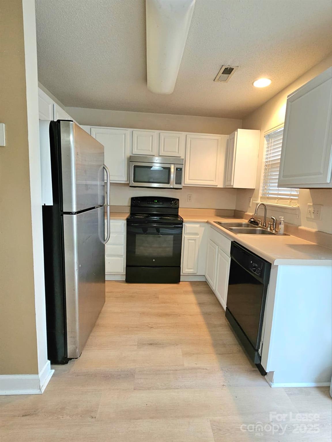 a kitchen with a refrigerator stove and microwave