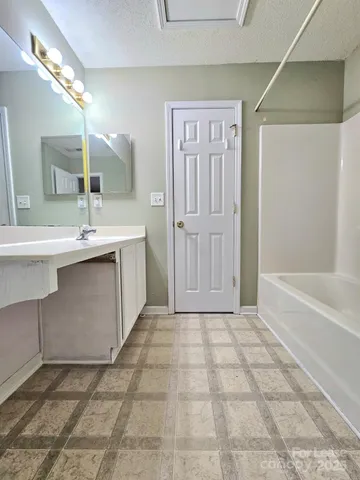 a bathroom with a sink a mirror and a bathtub