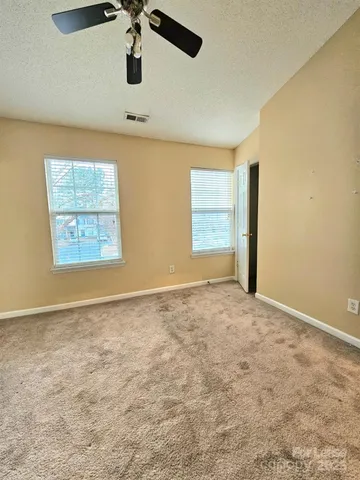 an empty room with windows and cabinet