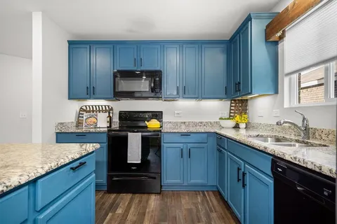a kitchen with sink a microwave and wooden cabinets