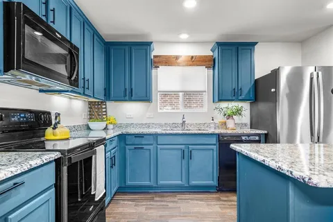 a kitchen with granite countertop a sink stove and refrigerator