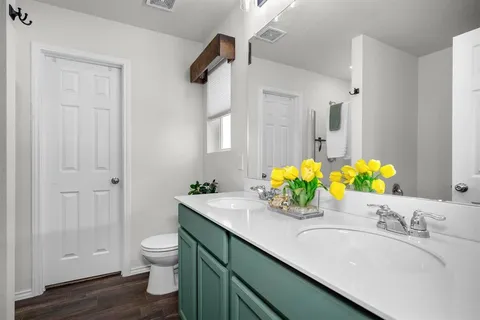 a bathroom with a granite countertop sink a toilet and a mirror