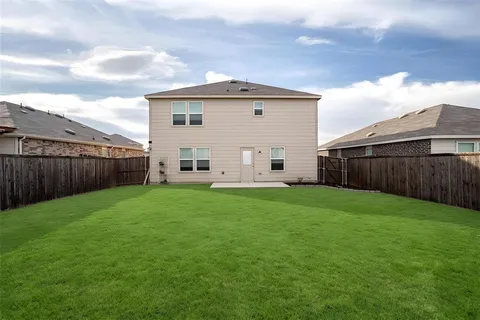 a view of a backyard with wooden fence