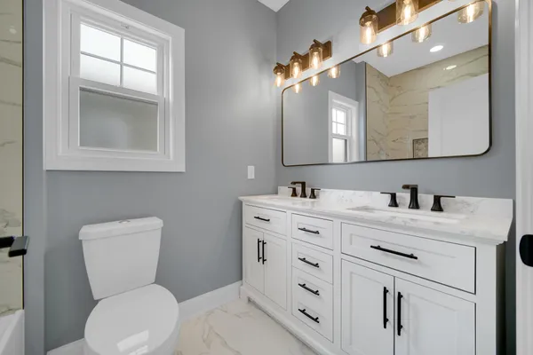 a bathroom with a toilet sink and mirror