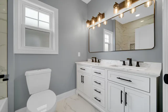 a bathroom with a toilet sink and mirror