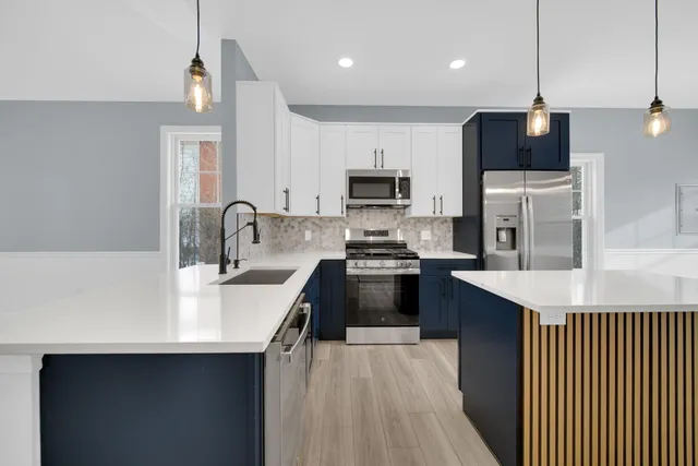 a kitchen with kitchen island a sink appliances and cabinets