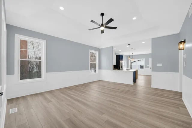 a view of empty room with wooden floor and window