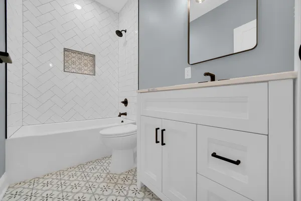 a bathroom with a toilet a sink a mirror and vanity