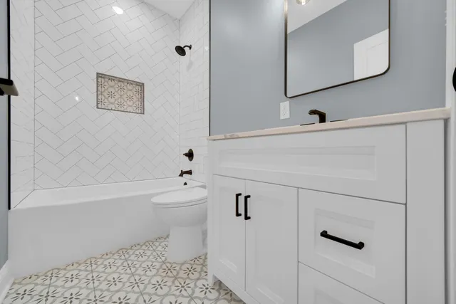 a bathroom with a toilet a sink a mirror and vanity