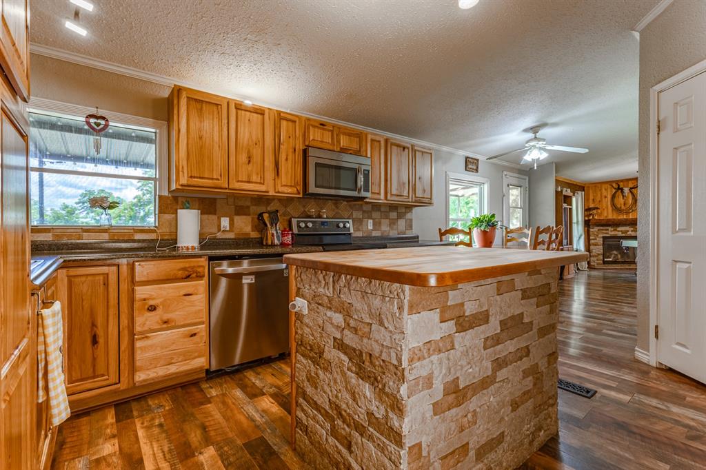 75 Southern Road Mineral Wells, TX 76067 - Photo 5 of 31 a kitchen with stainless steel appliances granite countertop a stove a sink dishwasher and a refrigerator