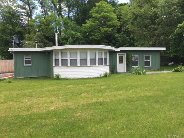 a view of a house with a garden and trees