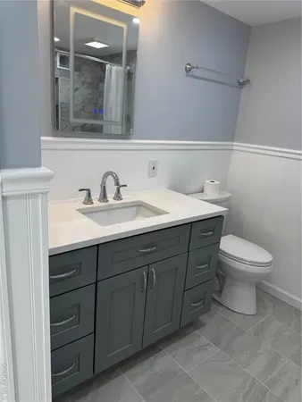 a bathroom with a toilet sink and mirror
