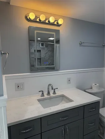 a bathroom with a sink and two mirror