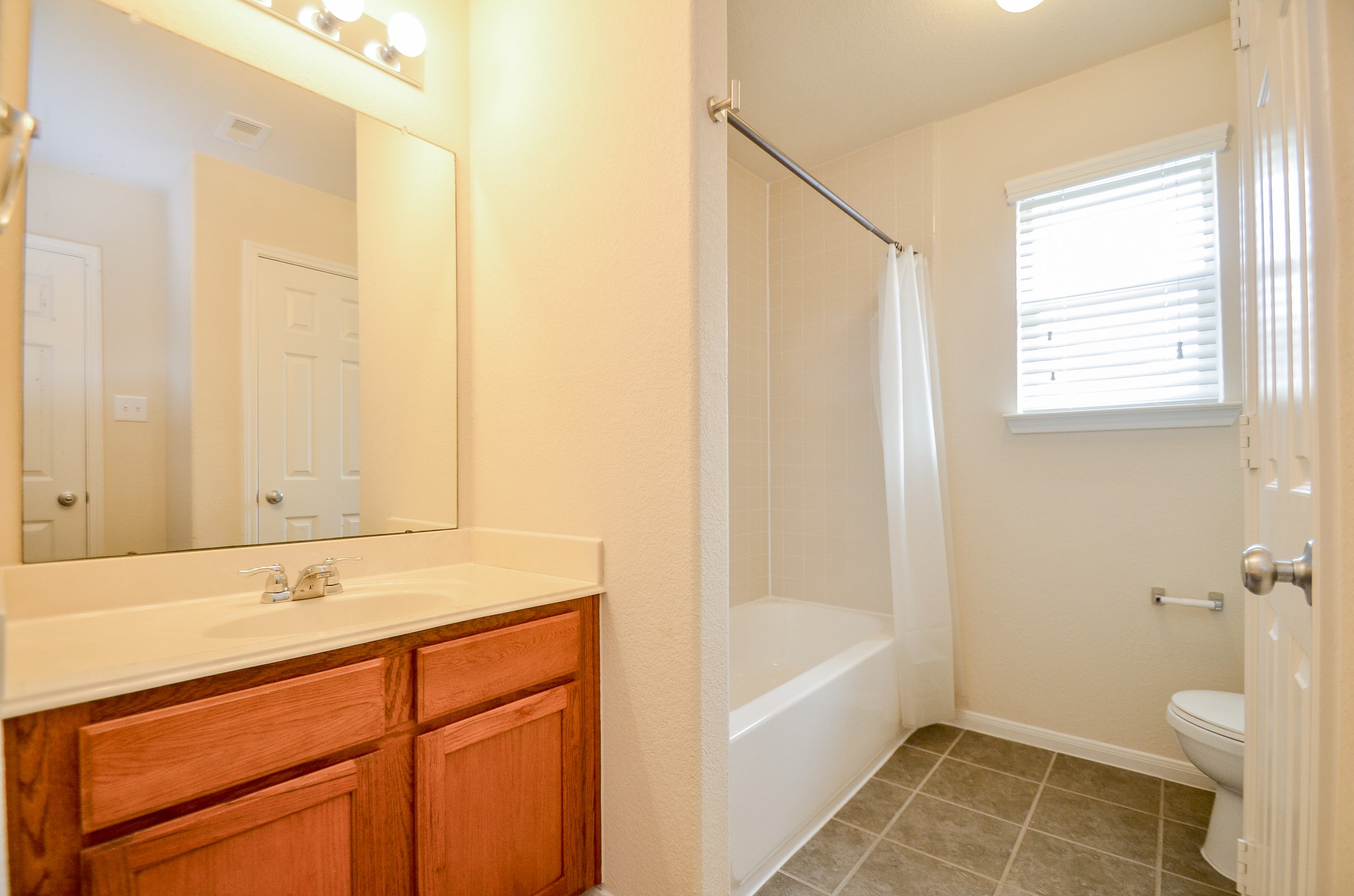 2903 Gaelic Green Street Houston, TX 77045 - Photo 22 of 32 a bathroom with a granite countertop sink a toilet and shower