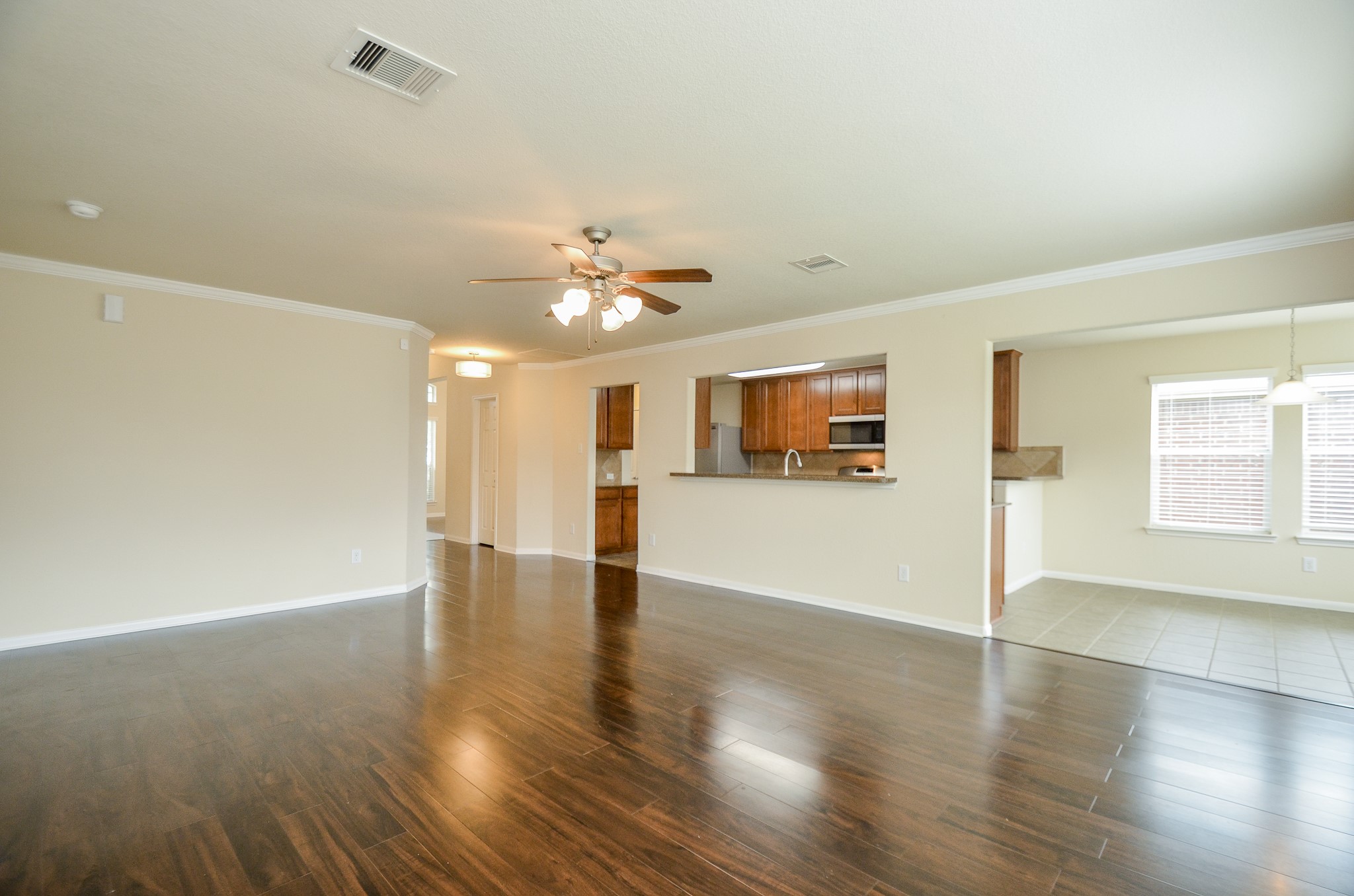 2903 Gaelic Green Street Houston, TX 77045 - Photo 9 of 32 a view of a kitchen with an empty room and wooden floor