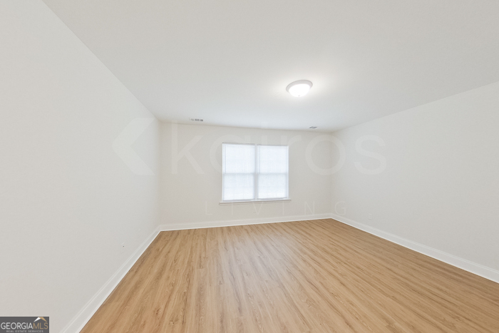 231 Western Red Cedar Drive Springfield, GA 31329 - Photo 18 of 26 an empty room with wooden floor and windows