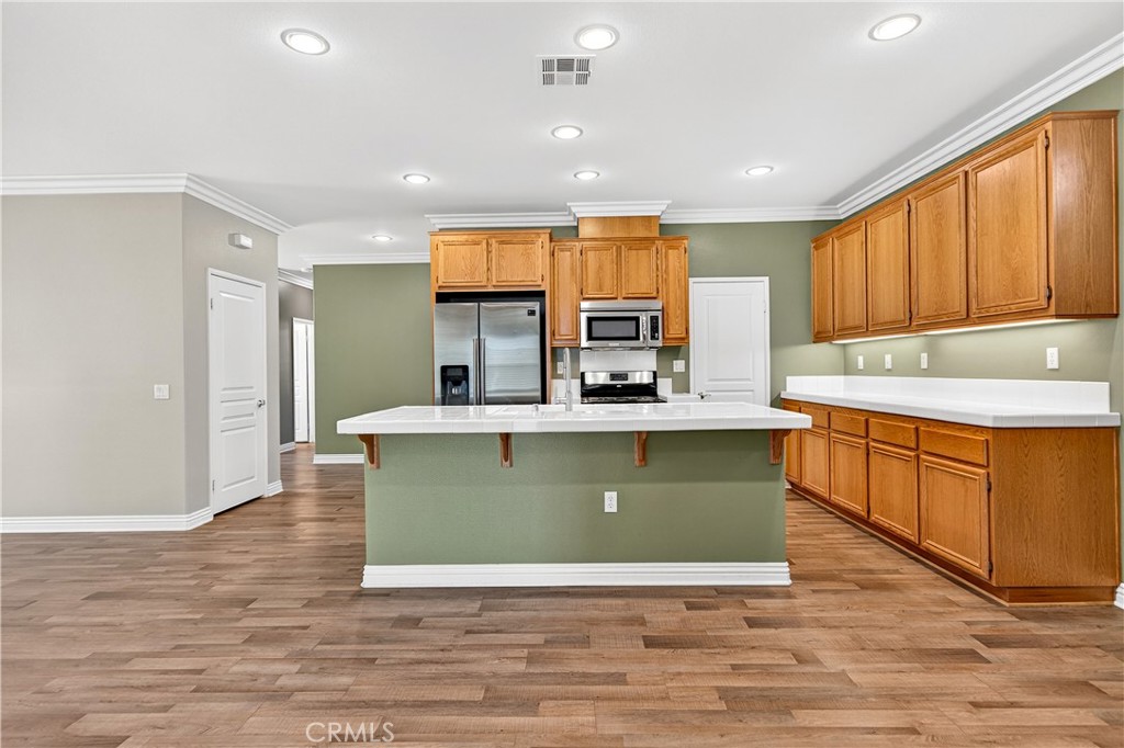 215 Firestone Lane Hemet, CA 92545 - Photo 21 of 61 a view of kitchen with stainless steel appliances granite countertop a stove top oven a sink dishwasher and a refrigerator with wooden floor