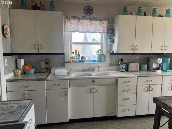 a kitchen with cabinets appliances a sink and a window