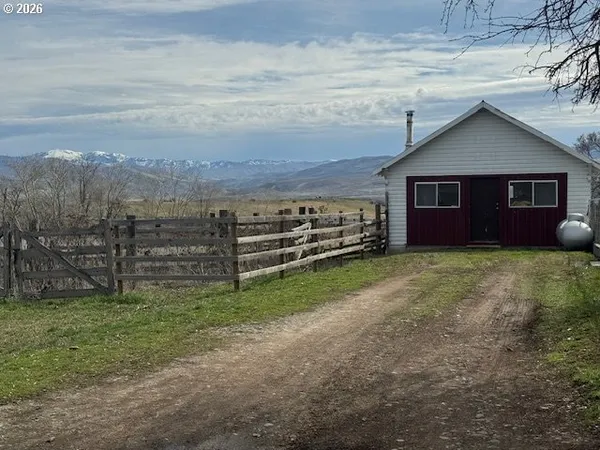 a view of a yard in front of a house with wooden fence