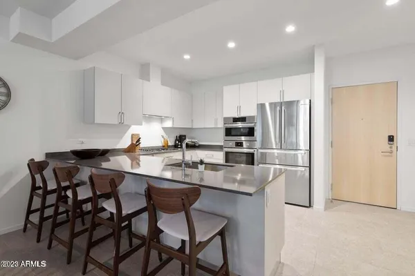 a kitchen with granite countertop white cabinets stainless steel appliances and sink