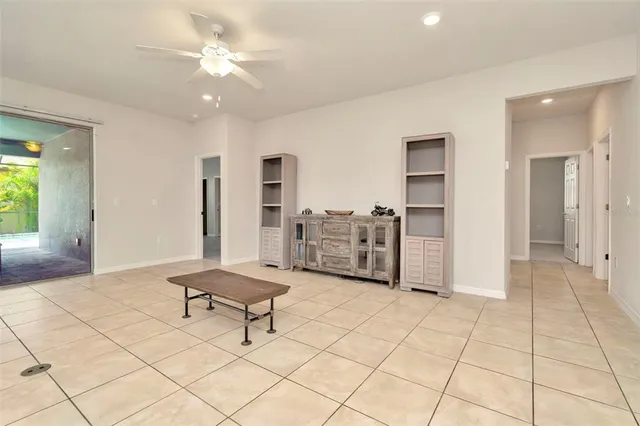 an empty room with windows and fan