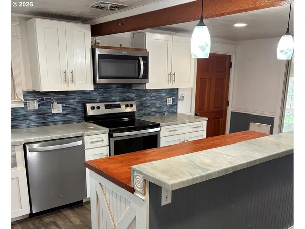 a kitchen with stainless steel appliances a stove microwave and sink