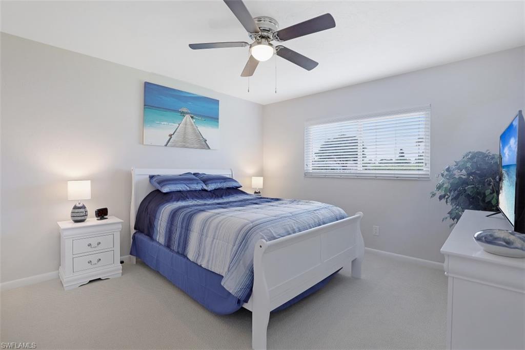 701 93rd Avenue North Naples, FL 34108 - Photo 17 of 33 a bedroom with a bed and a chandelier