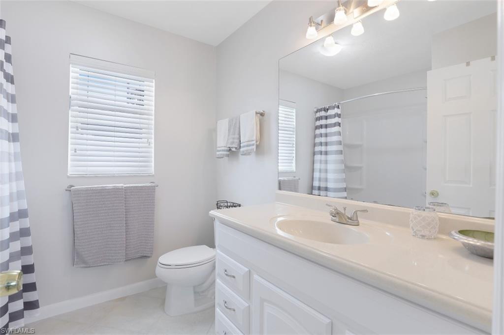 701 93rd Avenue North Naples, FL 34108 - Photo 19 of 33 a bathroom with a sink a toilet and a mirror
