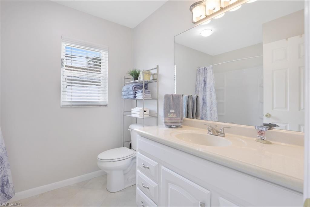701 93rd Avenue North Naples, FL 34108 - Photo 21 of 33 a bathroom with a sink a toilet and a mirror