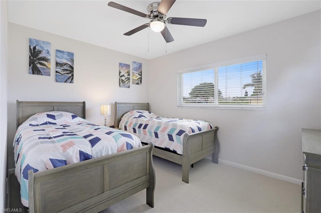 701 93rd Avenue North Naples, FL 34108 - Photo 22 of 33 a bedroom with two beds and a chandelier