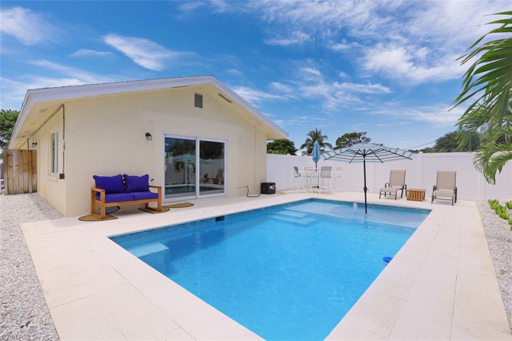 701 93rd Avenue North Naples, FL 34108 - Photo 27 of 33 a view of a house with pool and dining table