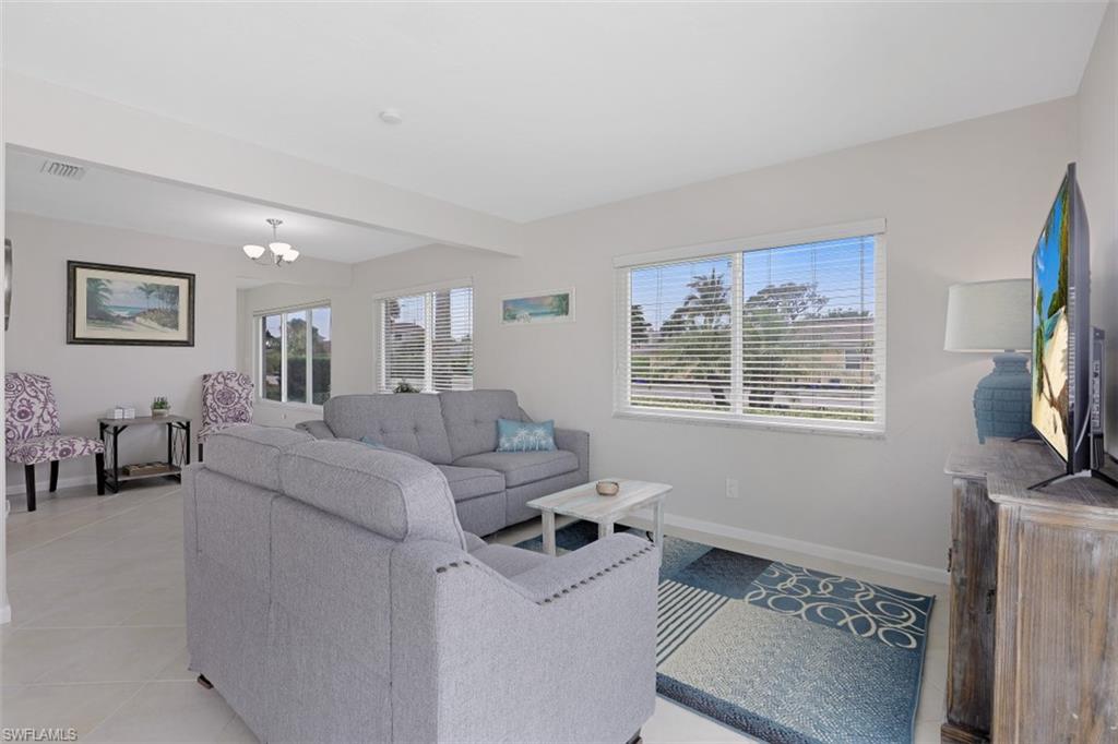 701 93rd Avenue North Naples, FL 34108 - Photo 8 of 33 a living room with furniture and a flat screen tv