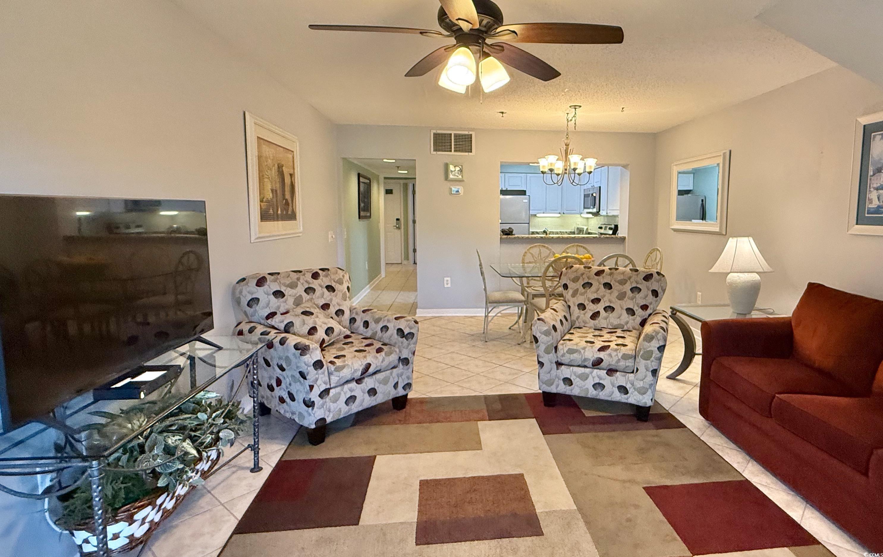 410 Melrose Place, Unit 310 Myrtle Beach, SC 29572 - Photo 12 of 39 Living area with a chandelier, light tile patterned floors, and a ceiling fan