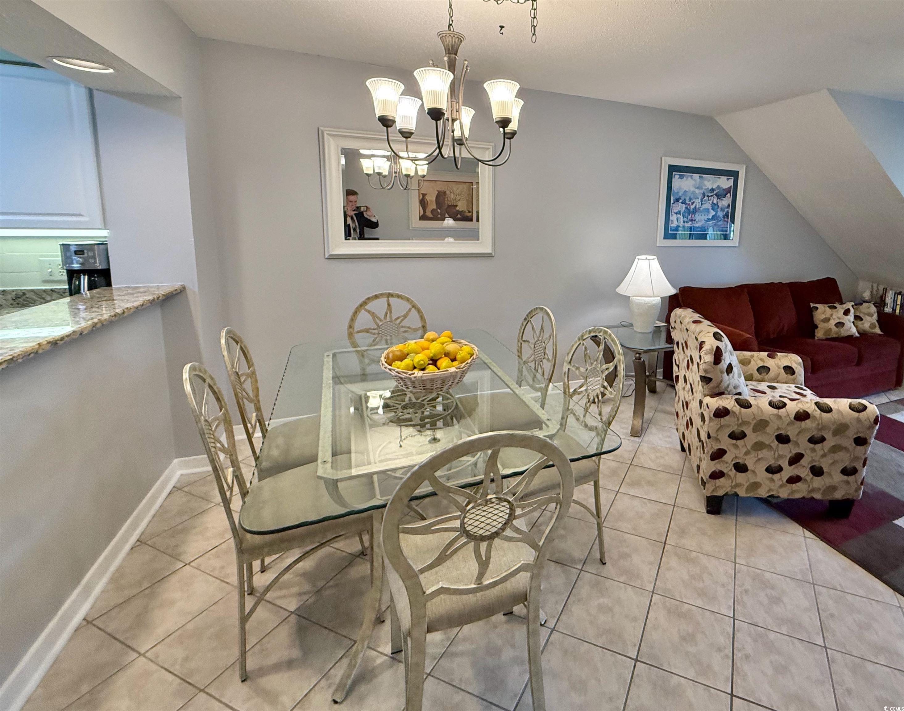 410 Melrose Place, Unit 310 Myrtle Beach, SC 29572 - Photo 13 of 39 Dining room with light tile patterned floors and a chandelier