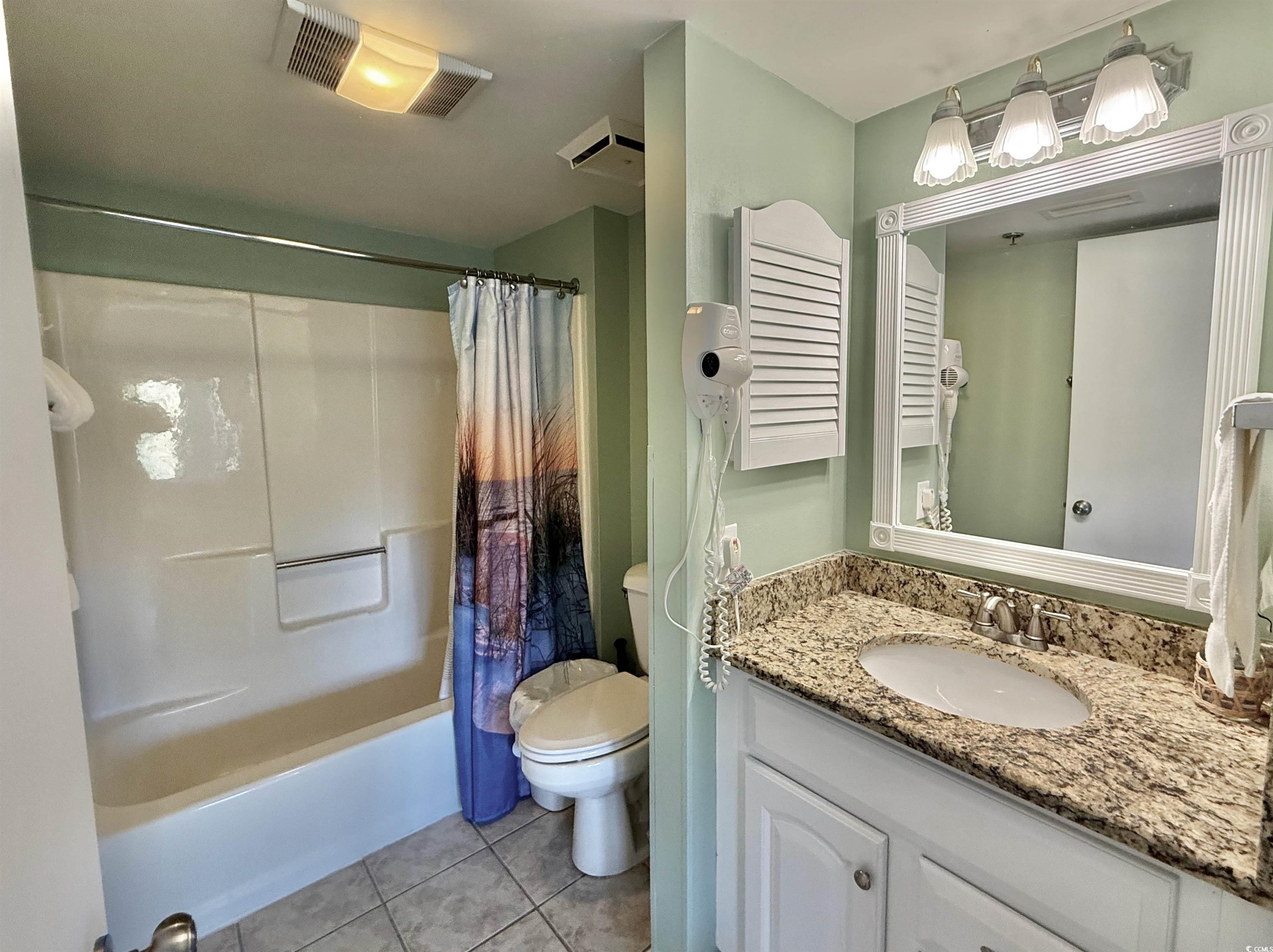 410 Melrose Place, Unit 310 Myrtle Beach, SC 29572 - Photo 26 of 39 Full bath with vanity, light tile patterned flooring, and shower / tub combo with curtain