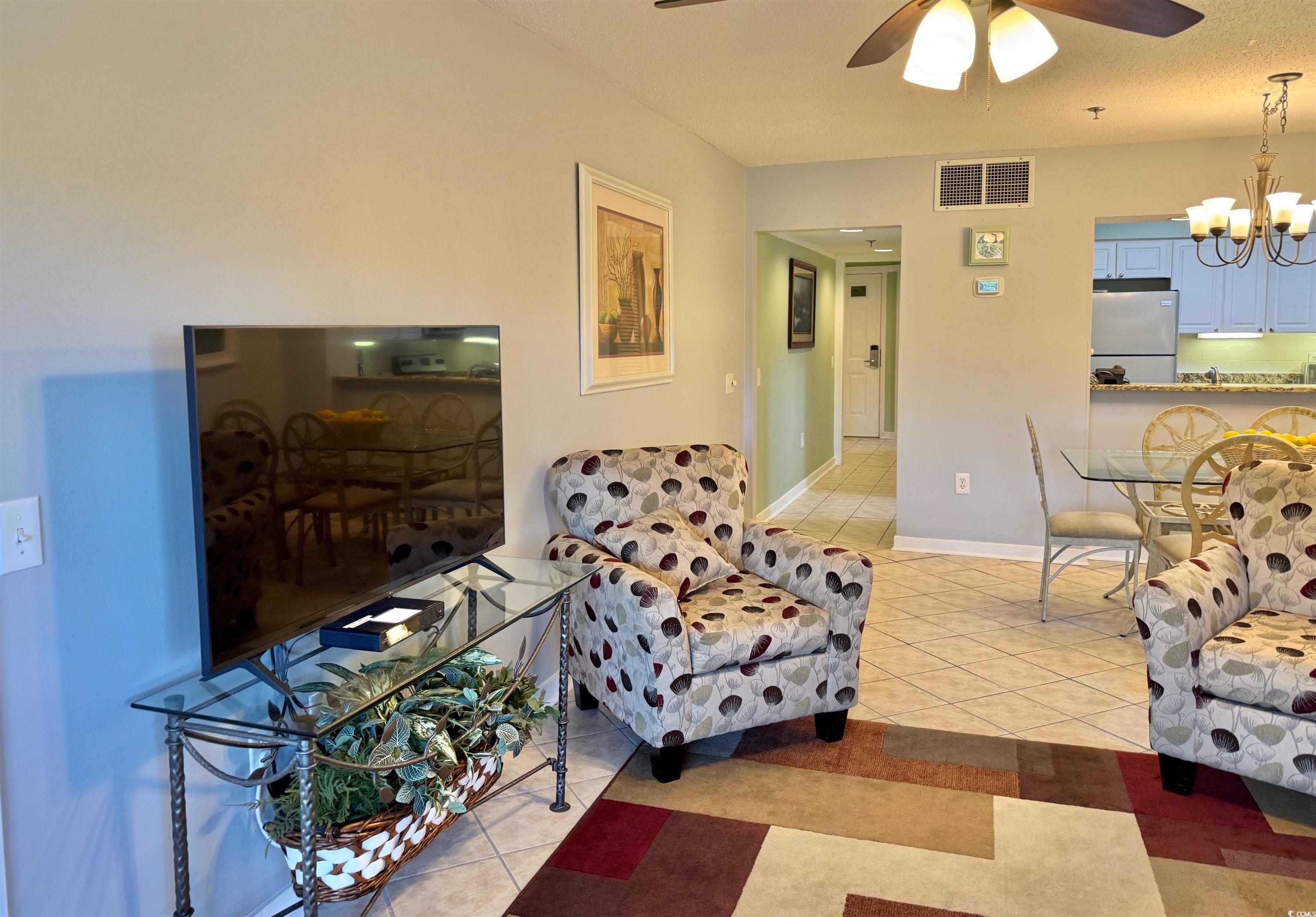 410 Melrose Place, Unit 310 Myrtle Beach, SC 29572 - Photo 28 of 39 Living area with light tile patterned flooring, a chandelier, and ceiling fan